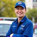 Portrait of David Chen, a cheerful rideshare driver in front of his car